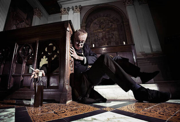A drunk priest regains just enough composure to find his whisky.