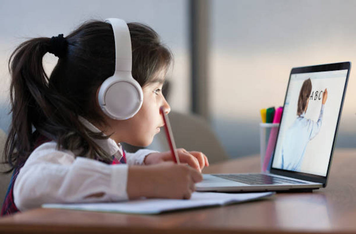 Little Girl Attending To Online School Class On Laptop Computer