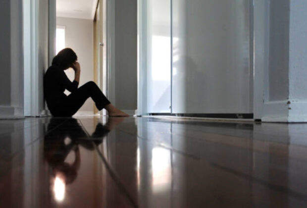 Sad Adult Woman Sitting On Dark Home Corridor Floor