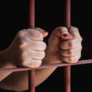 Hands of muslim woman holding bars in jai
