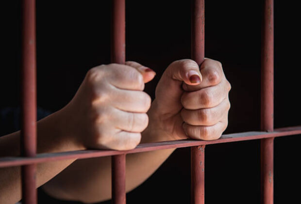 Hands of muslim woman holding bars in jai