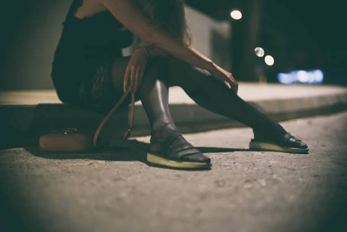 Drunk Woman In Dress Sits On The Roadside At Night.