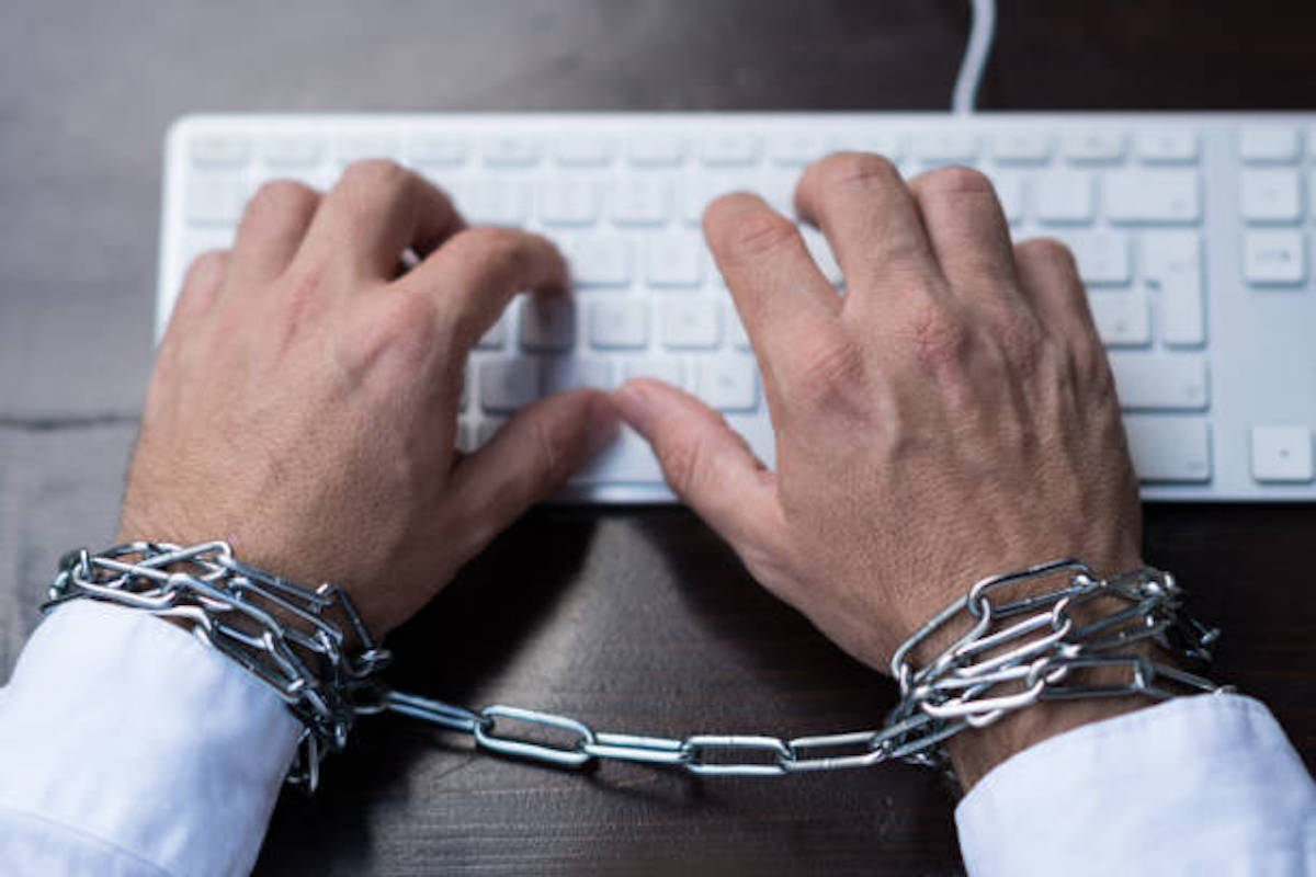 Businessman Hands Tied With Chains On Wrists Typing On Laptop Keyboard